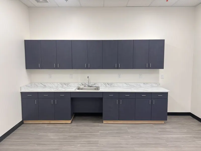 Dark cabinetry with a light stone-pattern countertop.
